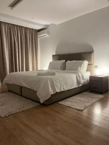 une chambre avec un grand lit avec des draps et des oreillers blancs dans l'établissement Appartement luxueux prestigia, à Rabat 7 autres photos