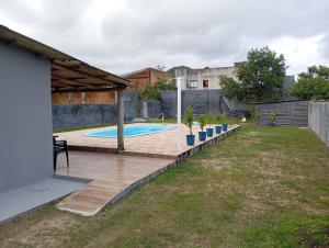 a backyard with a swimming pool with a wooden deck at Tô na praia in Matinhos