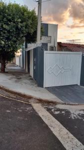 a white fence on the side of a street at Wana casa 5 requinte e conforto in Sao Jose do Rio Preto