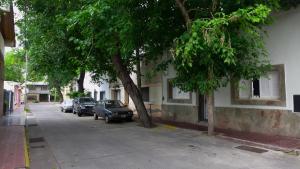 una calle con coches estacionados al lado de un edificio en Apartamento Las Orquideas en Mendoza