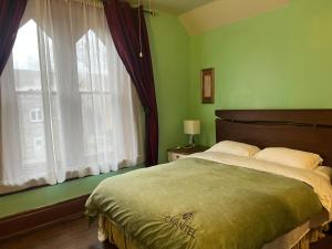 a bedroom with a large bed and a window at THE RED STAR ROOM A in Niagara Falls +3 photos