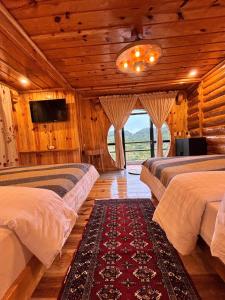 um quarto com três camas e uma televisão num quarto em The Shire of Sagada em Sagada