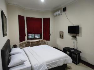a bedroom with a white bed and a window at Tirto 27 homestay in Yogyakarta