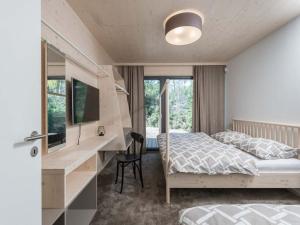 a bedroom with a bed and a desk with a computer at Villa in Bohemia with barbecue in Bedřichov