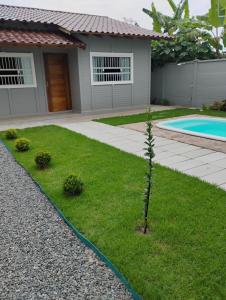 a small tree in a yard in front of a house at Casa e conforto in Itapoa