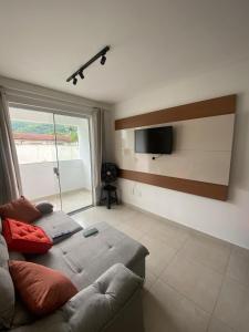 a living room with a couch and a flat screen tv at Apto no Caminho das Praias in Balneário Camboriú