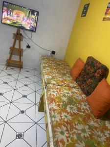 a bedroom with a bed and a television on a tripod at Morada Vitória in Ubatuba