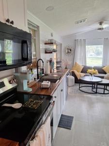 une cuisine avec un comptoir noir et un salon dans l'établissement Your home away from home! Entire cottage- Disney, à Kissimmee