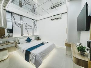 a bedroom with a large bed and a tv at Ngoc San San Hotel HCM in Ho Chi Minh City