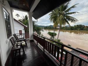 a balcony of a house with a view of a river at Maophasok river side hotel in Luang Prabang