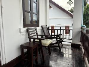 two chairs sitting on the porch of a house at Maophasok river side hotel in Luang Prabang