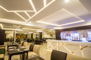 ガントクにあるDaizzo Hotelsのテーブルと椅子とバーのあるレストラン