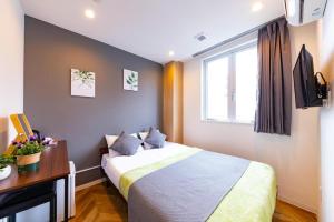 a bedroom with a bed and a desk and a window at JA Hotel Tennoji in Osaka