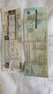 two tickets sitting on top of a white blanket at Penginapan Bunga Sonsang kamar Family Tripel in Sungaidaras