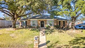 a brick house with a tree in the yard at Your Home Away from Home in Grand Prairie