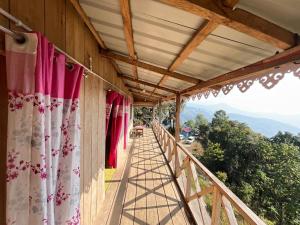 a balcony of a house with red and white curtains at Katus in Gangtok +38 photos