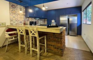 亚松森Casa moderna en Villamorra a pasos del Shopping Mariscal Lopez 2Dorm,2 garajes y Wifi的厨房设有蓝色的墙壁和带凳子的台面。