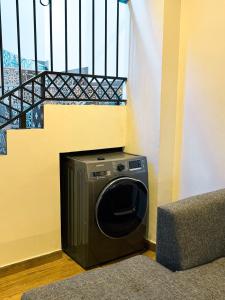 亚松森Casa moderna en Villamorra a pasos del Shopping Mariscal Lopez 2Dorm,2 garajes y Wifi的楼梯旁边的房间内的洗衣机