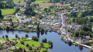 an aerial view of a town next to a river at Maison de village proche du Lac de Vassivière in Peyrat-le-Château