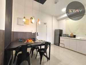 a kitchen with a black table and chairs in a room at Meridin Sovo 1Bed Healing Space Netflix By STAY in Iskandar Puteri