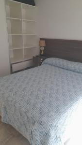Un dormitorio con una cama con un edredón azul. en Casa con Patio y Parrilla Zona Golf, en Villa Gesell