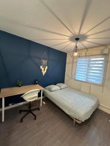 una camera da letto con un letto, una scrivania e una scrivania di Chez vous a Saint-Brieuc