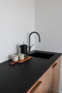 a kitchen counter with two cups and a sink at Mathea House in Richmond +28 photos
