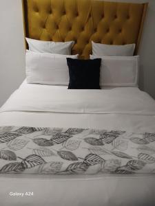 SERENE Guest House في ميدراند: سرير أبيض كبير مع اللوح الأمامي والوسائد كبيرة