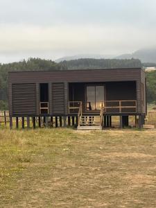 a log cabin with a porch in a field at Arenas Pullay in Pullay