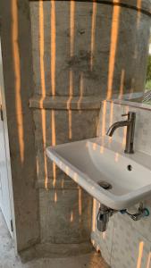 een witte wasbak aan de zijkant van een muur bij ที่พักแบบเต็นท์ Waraporn Valley in Ban Nong Tum