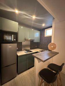 a kitchen with a counter and a stove and a refrigerator at Repère cosy in Saint-Brieuc