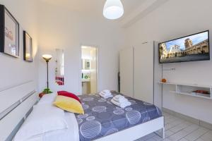una camera da letto con un letto e una TV a parete di Home4Apartment 2, Salerno cathedral area a Salerno