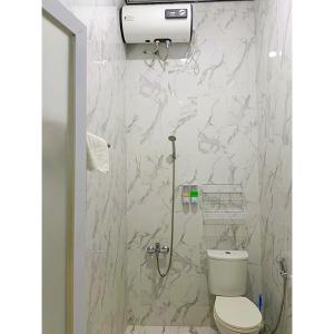 a white bathroom with a toilet and a shower at Athallah Homestay Syariah in Lampung +15 photos