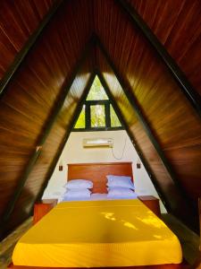a bedroom with a yellow bed in a triangle shaped room at Agora Field in Hikkaduwa