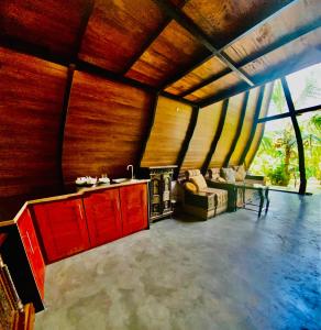 a kitchen with red cabinets and a living room at Agora Field in Hikkaduwa