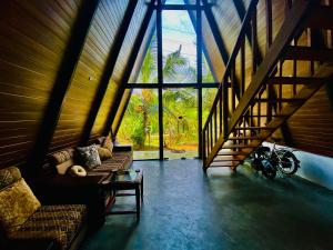 a living room with couches and a large window at Agora Field in Hikkaduwa