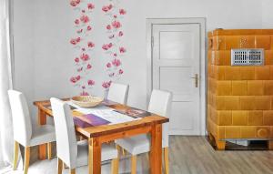 ein Esszimmer mit einem Holztisch und weißen Stühlen in der Unterkunft Ferienhaus Mirow Ot Qualzow in Qualzow + 12 Fotos
