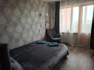 a bedroom with a bed and a chair and a window at Between Lake and Sea in Liepāja