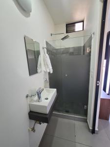 a white bathroom with a shower and a sink at Depa los robles fracc aldea hortus in Naranjo