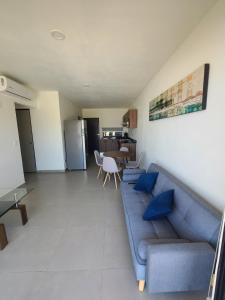 a living room with a blue couch and a table at Depa los robles fracc aldea hortus in Naranjo +4 photos