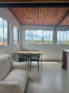 a living room with a couch and tables and windows at Apt Maracaipe, Porto de Galinhas in Porto De Galinhas