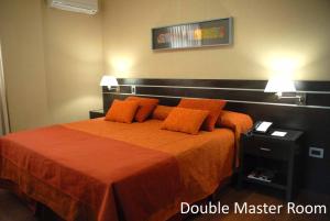a bedroom with a bed with orange sheets and pillows at Hotel Francia in San Miguel de Tucumán