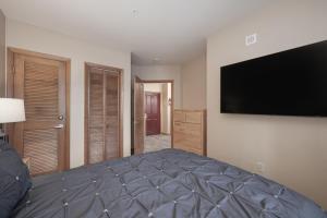 a bedroom with a bed with a large television on the wall at Premium Unit 2216 - 1 Br - Zephyr Mountain Lodge condo in Winter Park