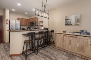a kitchen with a counter and bar with stools at Premium Unit 2216 - 1 Br - Zephyr Mountain Lodge condo in Winter Park