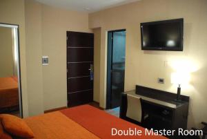 a bedroom with a bed and a television on the wall at Hotel Francia in San Miguel de Tucumán