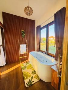 een grote badkamer met een groot bad en een raam bij Chewavethee Herb Wellness Stay in Ban Chae Phang (1) +44 foto's