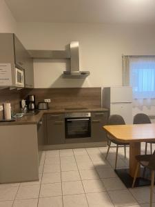 kuchnia z kuchenką i stołem z krzesłami w obiekcie Appartement Berger w mieście Zell am See