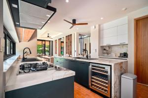 a kitchen with white cabinets and a stove top oven at Banyan Tree Grand Residences by Banyan Living in Phuket Town