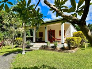 a house with a red door and some palm trees at Hospedaje Soma in Moyogalpa
