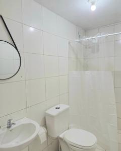 een witte badkamer met een toilet en een wastafel bij Casa ampla e confortável in Garanhuns